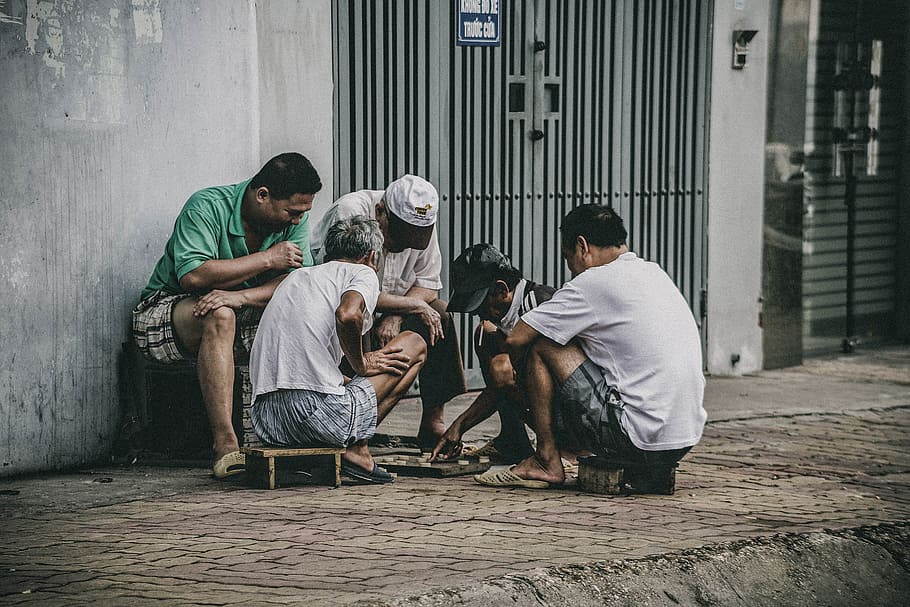 people playing beside street, three men watching two men playing board game on street during daytime HD wallpaper