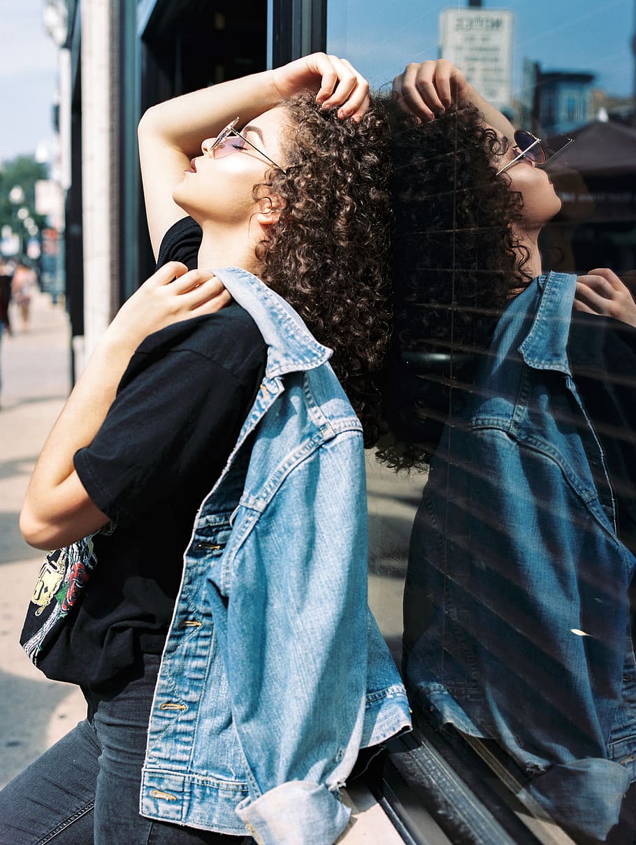 woman leaning on glass window, woman leaning on black glass while wearing sunglasses and holding grey denim jacket HD wallpaper