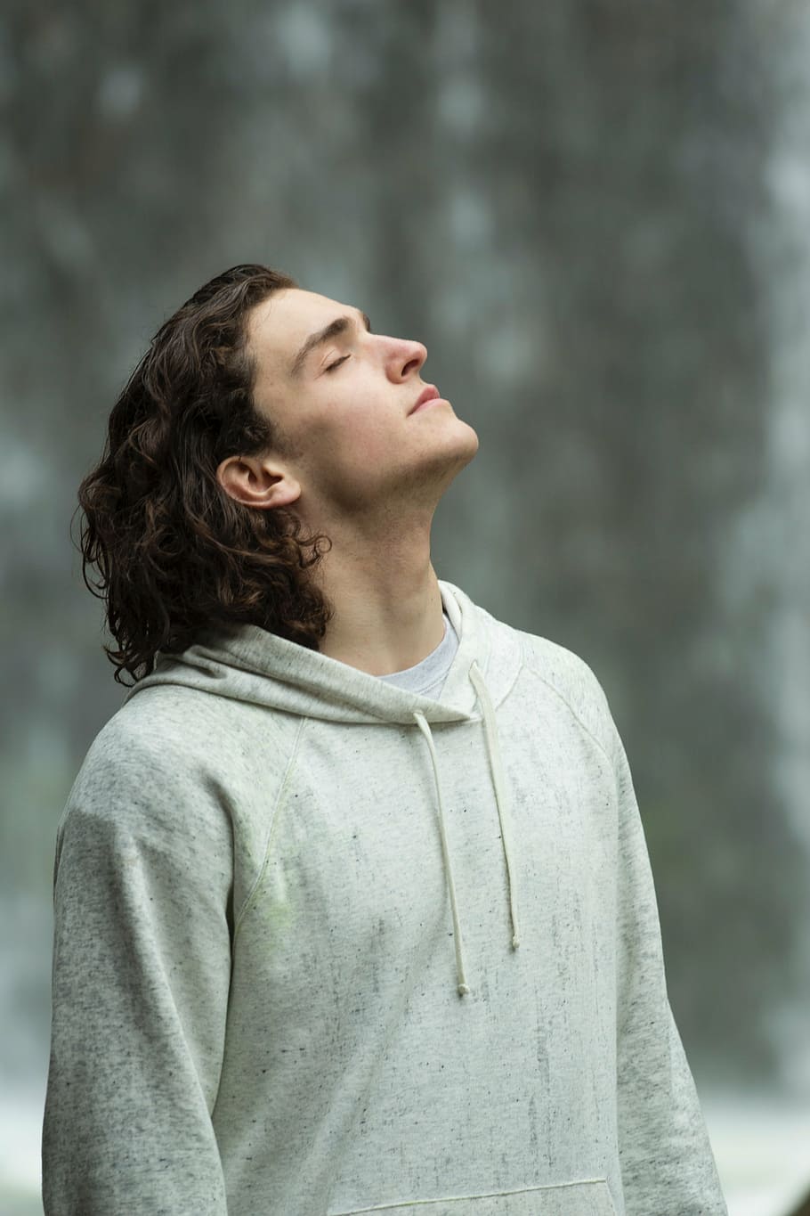 selective focus photography of man wearing white pullover hoodie standing on snow covered ground HD wallpaper