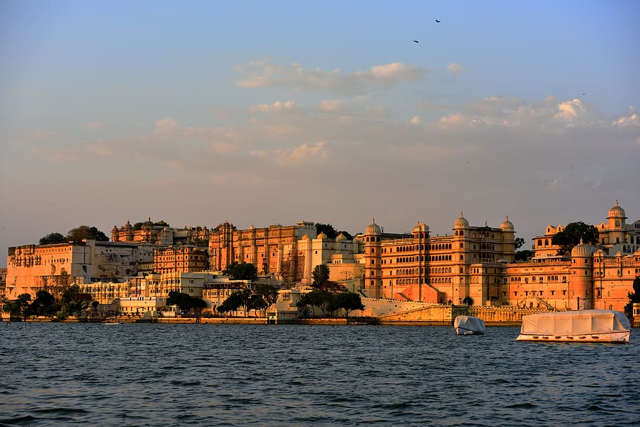 beige buildings near body of water under clear blue sky during daytime