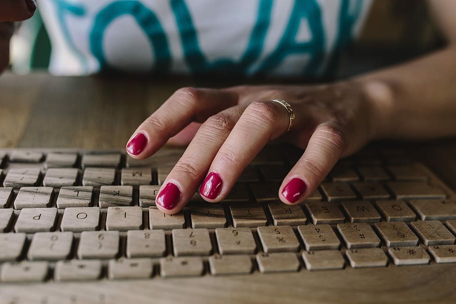 Closeup of female hands typing text on a wireless wooden keyboard, HD wallpaper