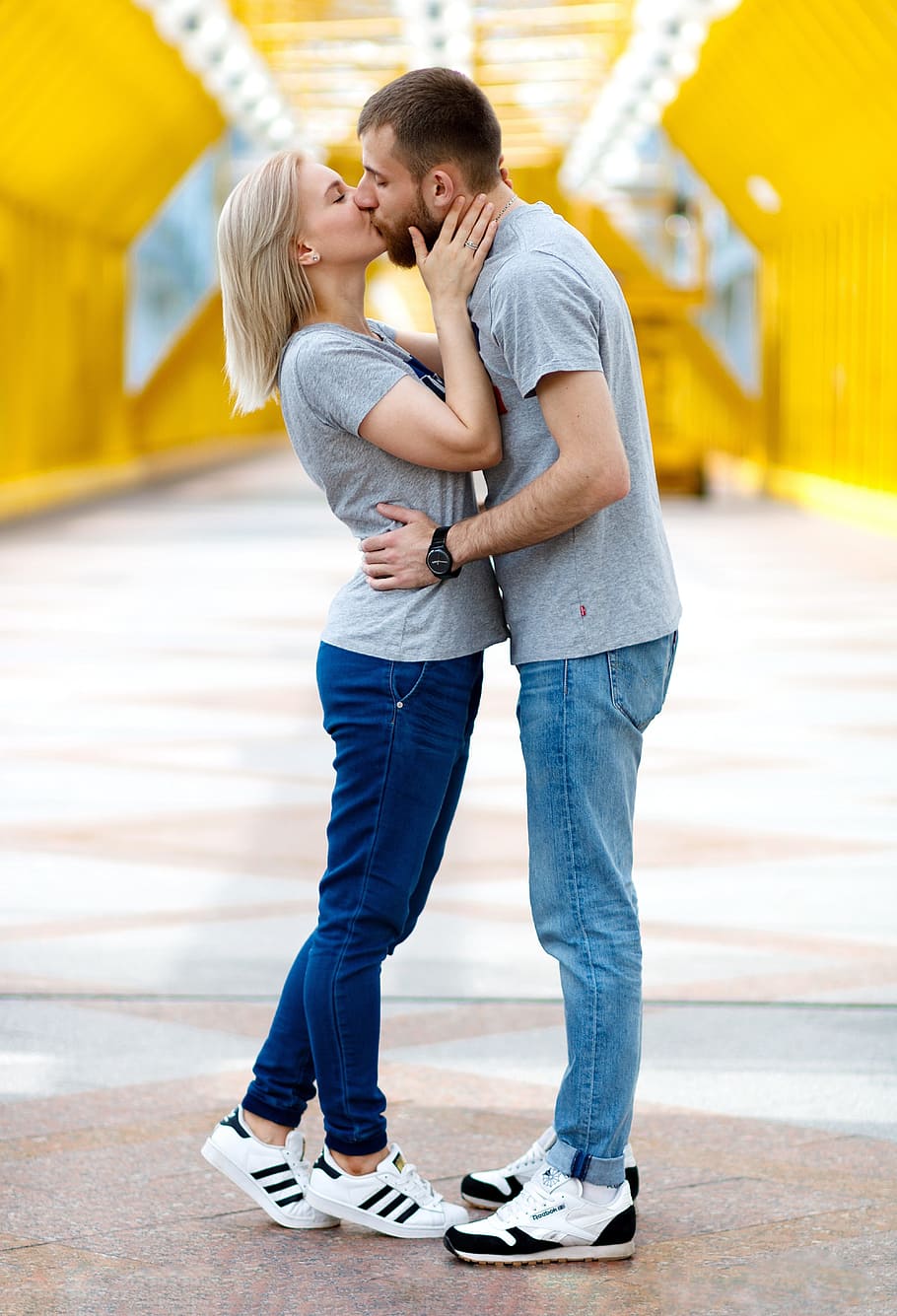 kissing couple in gray shirts with denim jeans and white-and-black shoes during daytime, HD wallpaper