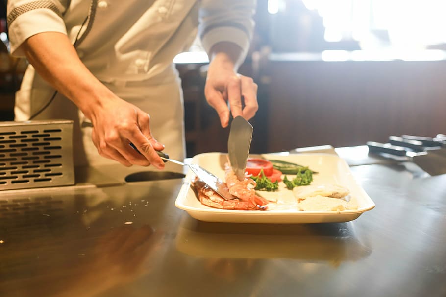 person preparing food on square white plate, restaurant, cooking