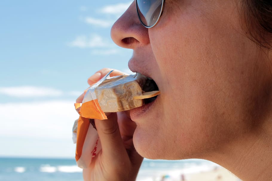 close up photography of person eating popsicle, ice cream, picole