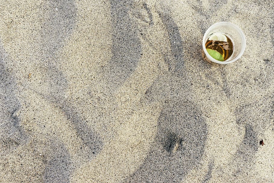 flat lay photography of clear disposable cup on gray sand, beach HD wallpaper