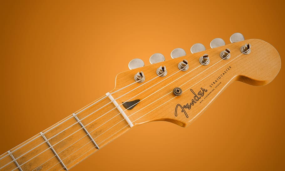 brown Fender guitar head, music background, colored background