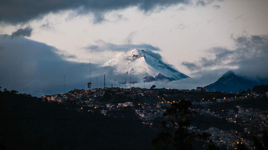 town with lights far from mountain field with snow, photo of houses and glacier mountain under cloudy sky HD wallpaper