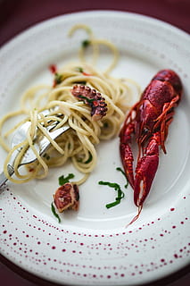 Fancy dinner with seafood pasta, crayfish and red wine by the table decorated with roses HD wallpaper