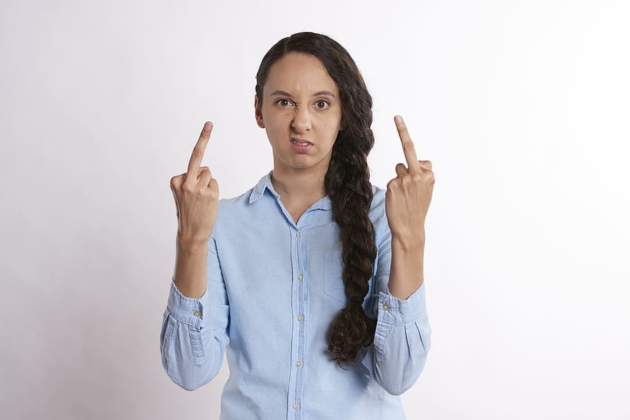 woman wearing blue dress shirt showing middle finger, upset, person
