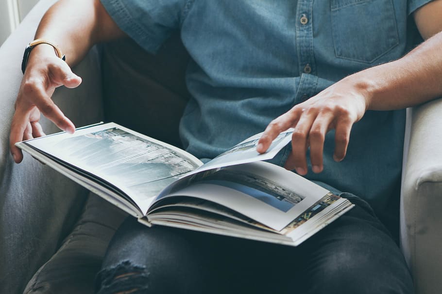 person sitting on sofa while reading book, person reading book HD wallpaper