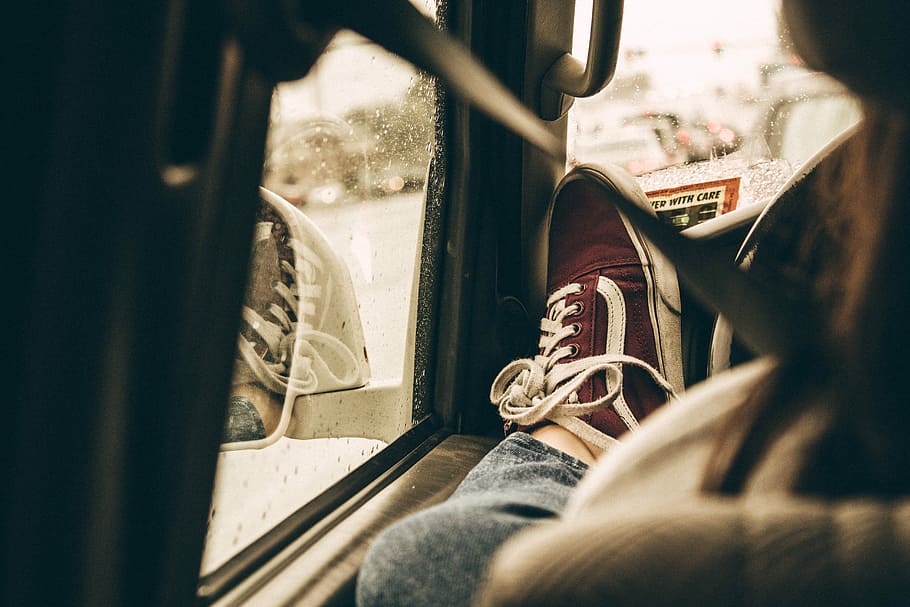 person showing red low-top sneaker, vans, shoes, shoelace, window seat