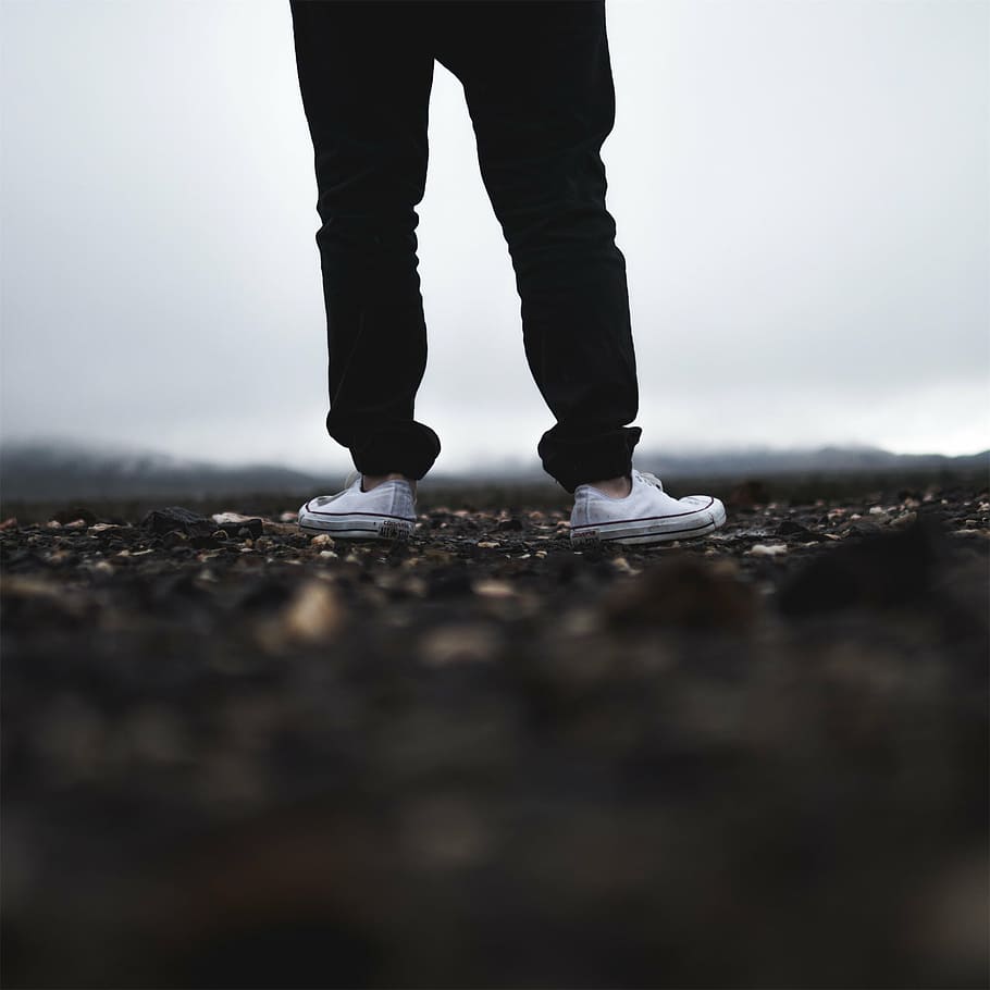 shallow focus photograph of person wearing black pants and white sneakers