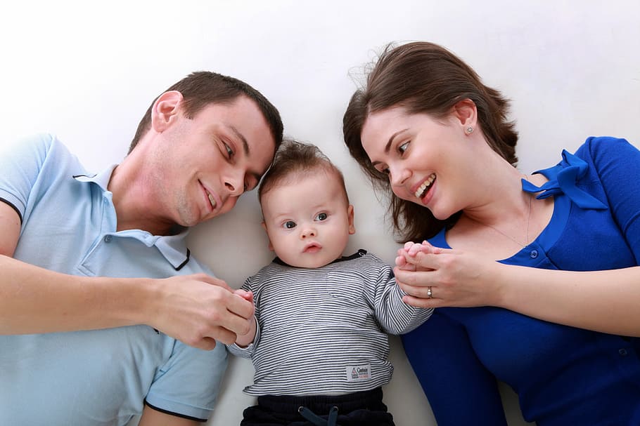 baby between man and woman holding their hands, family, toddler