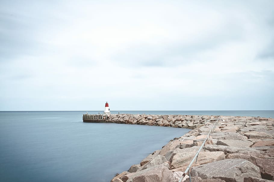 white and red lighthouse near sea at daytime, white and red lighthouse on rocks HD wallpaper