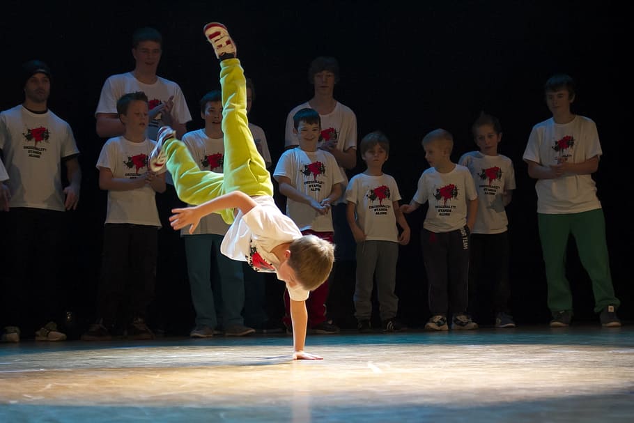 boy performing brake dance surround by people, hiphop, dance show