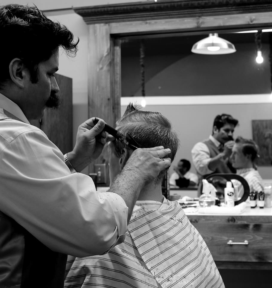 grayscale photography of man holding scissor, barber, haircut