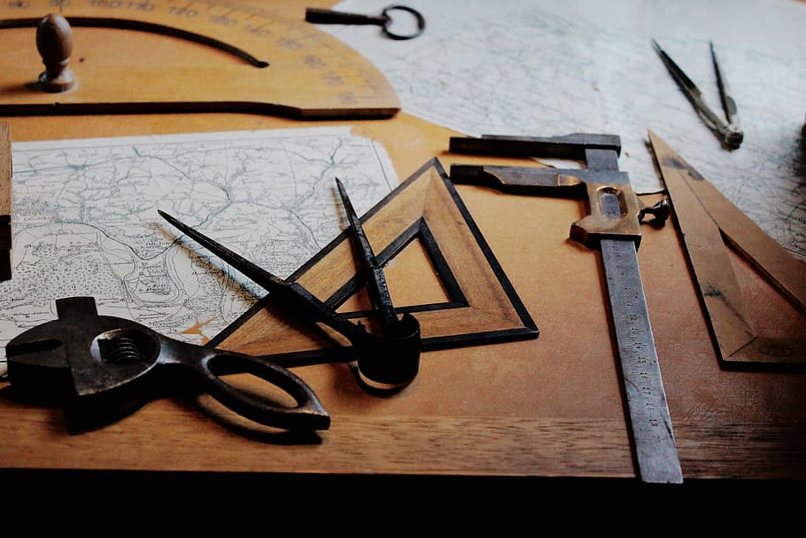 drafting instruments on top of table, gray rulers and black bow compass