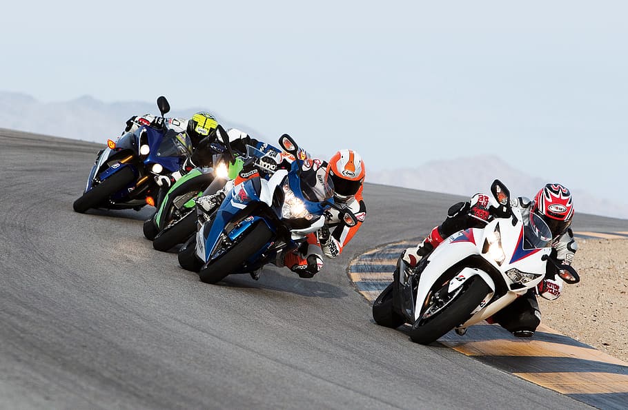 group of people riding sports motorcycles, photo of people riding on motorcycle racing on racetrack