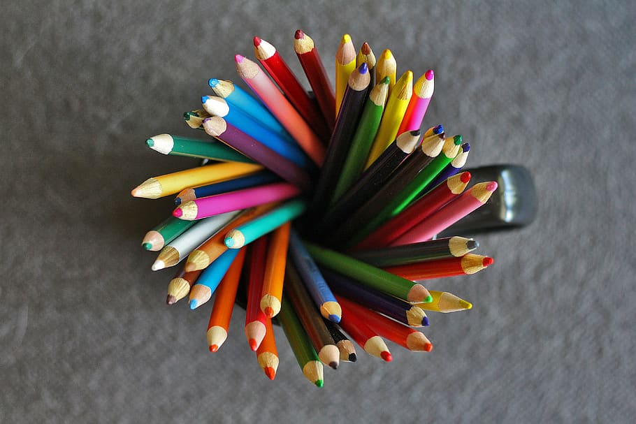 top-view photography of assorted-color pen in mug, pencils, colored pencils