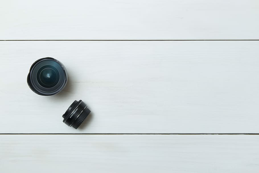 black camera lens on white board, two black telephoto lenses HD wallpaper