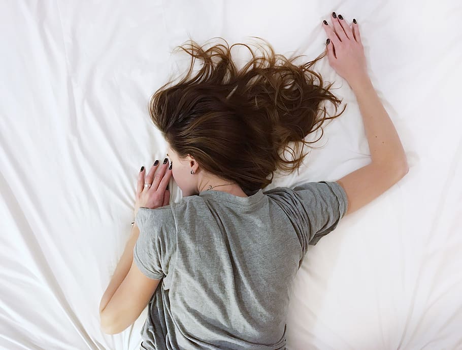 woman wearing gray t-shirt sleeping on white bed comforter HD wallpaper