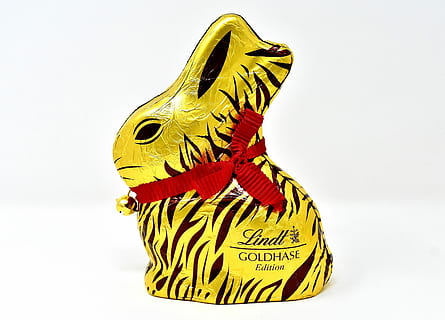 gold and black Lindt Goldhase Edition rabbit figure on white surface HD wallpaper