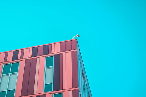 minimalist photography of high-rise building under blue sky, white lamp on top of brown building HD wallpaper