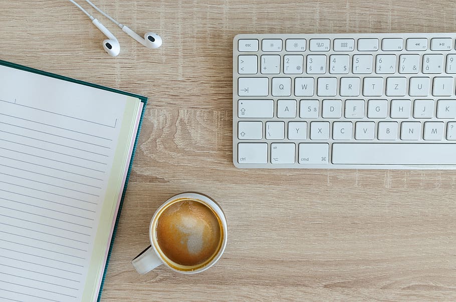 coffee latte near white wireless keyboard and Apple EarPods on the table photography, Apple Magic Keyboard beside of mug HD wallpaper