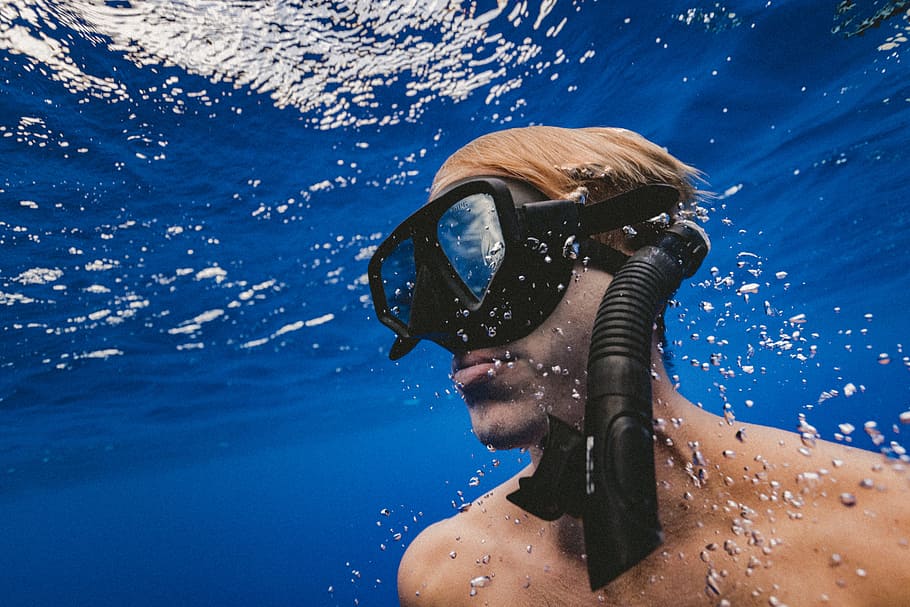 man wearing black goggles under water, man in black underwater goggles and snorkel in body of water