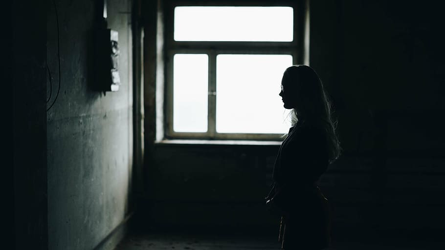 silhouette of woman facing wall beside windowpane, standing HD wallpaper
