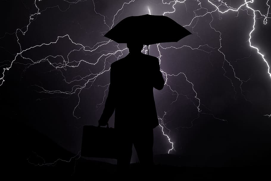 silhouette of man holding briefcase and umbrella, businessman