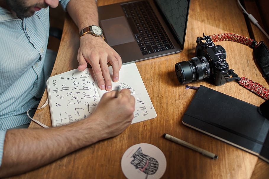 man writing on paper, laptop, computer, camera, electronic HD wallpaper