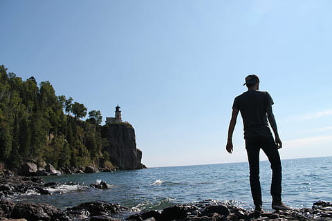 man standing on rack near body of water during daytime, men HD wallpaper