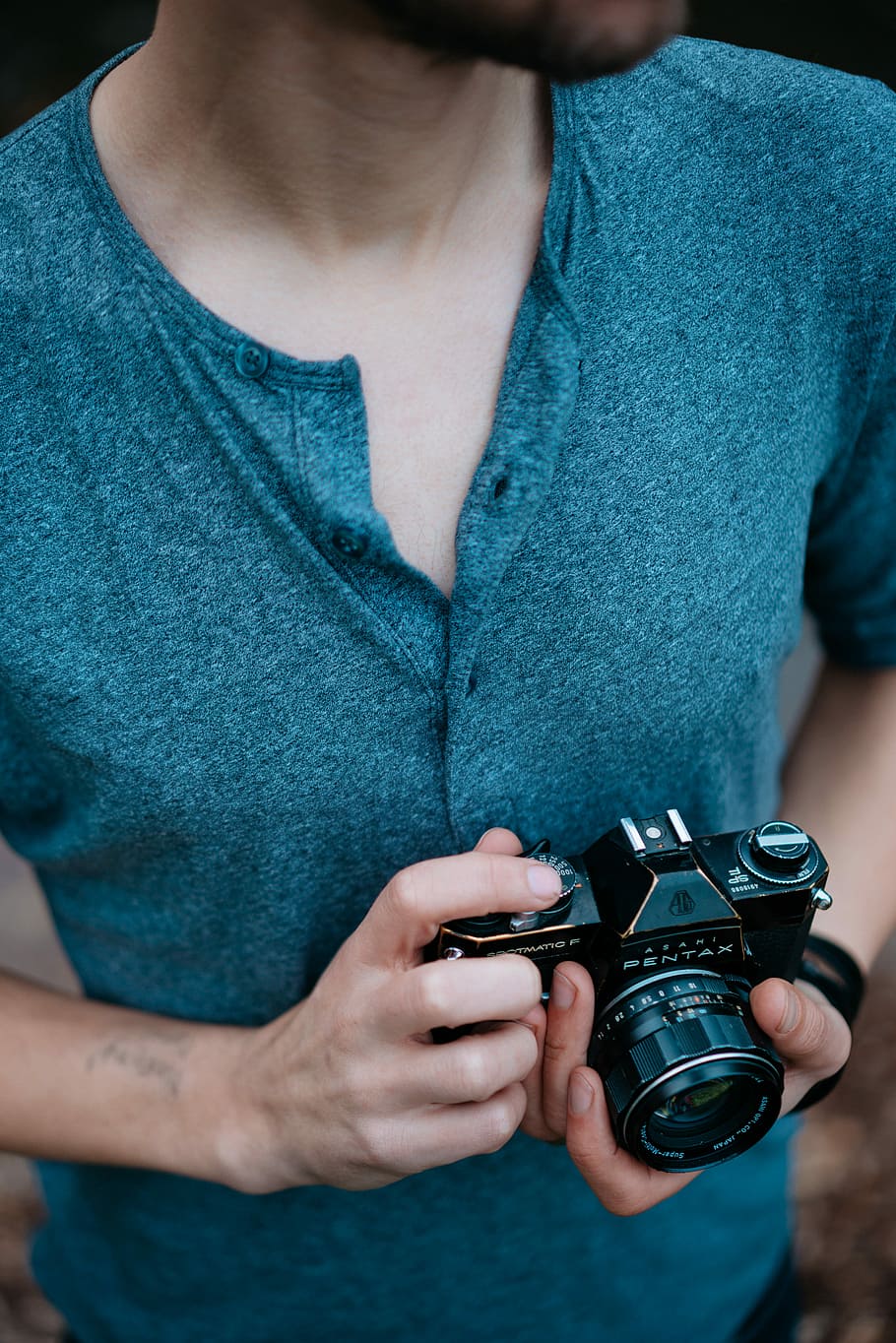 man holding Pentax SLR camera, person holding black DSLR camera HD wallpaper