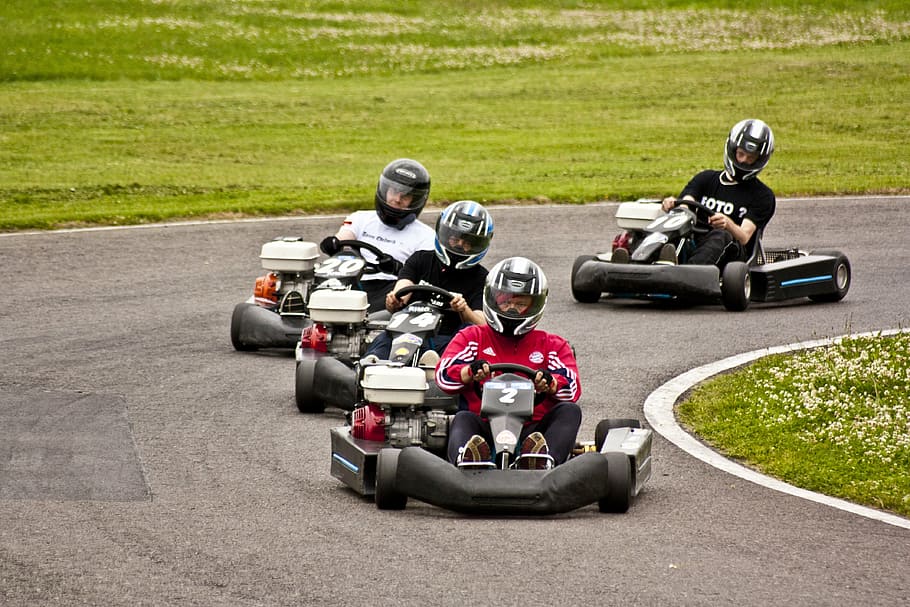 four men riding go-kart on road, go kart, race track, kart racing
