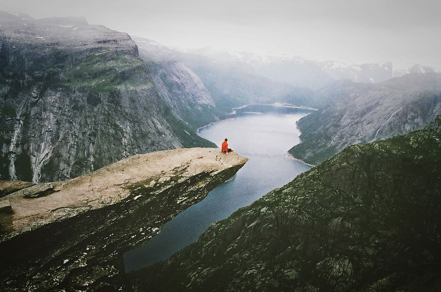 person wearing red shirt sitting on the boulder near the mountain, man sitting on mountain HD wallpaper