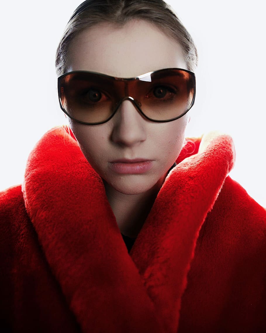 woman in red coat wearing brown sunglasses, man wearing butterfly sunglasses and red bathrobe while taking selfie