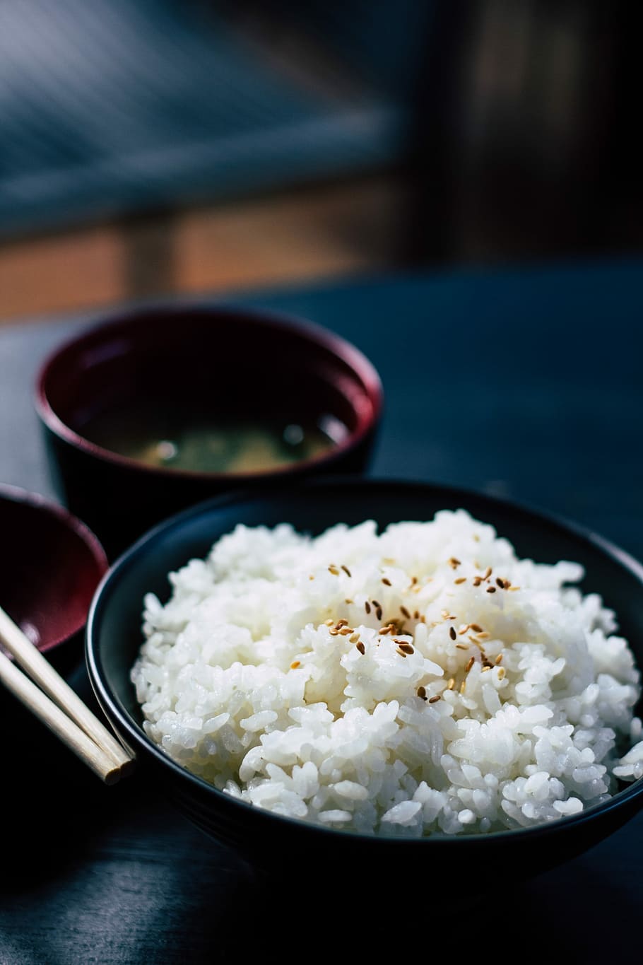 rice with sesame in black bowl, round black ceramic bowl with white rice