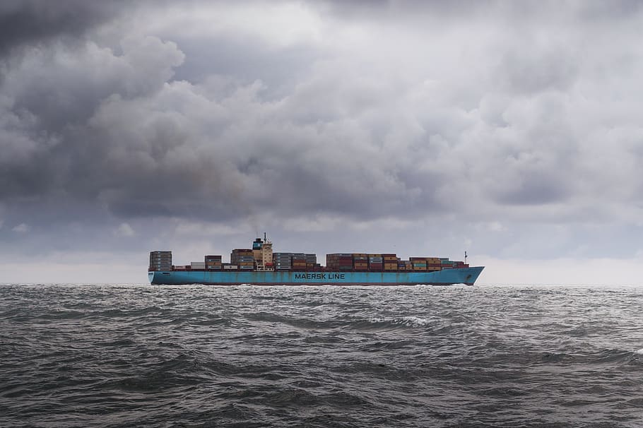 photo of blue cargo ship in body of water during daytime, container