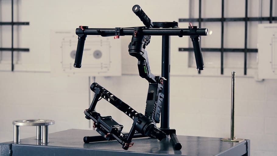 black camera stabilizer on top of gray metal table inside well lighted room, gray and black metal parts HD wallpaper