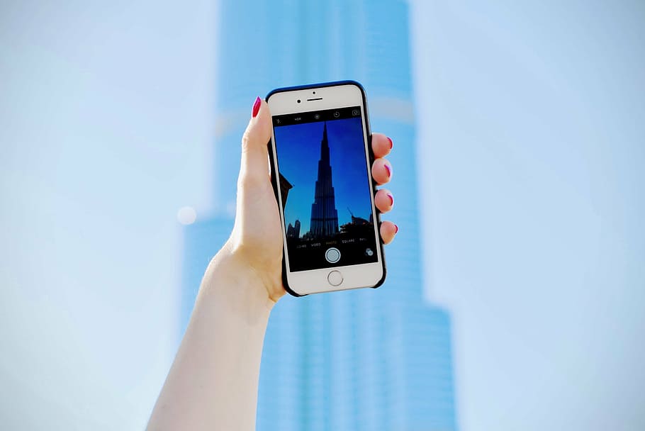 person taking a photo of Burj Khalifa building in Dubai during daytime, HD wallpaper