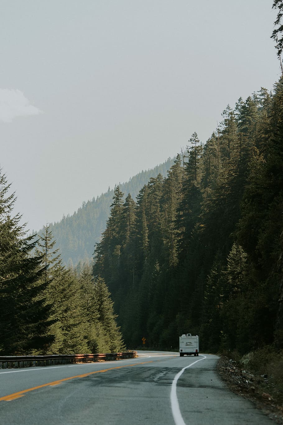 landscape photography of road and forest, white vehicle on road near green leaf tree at daytime HD wallpaper