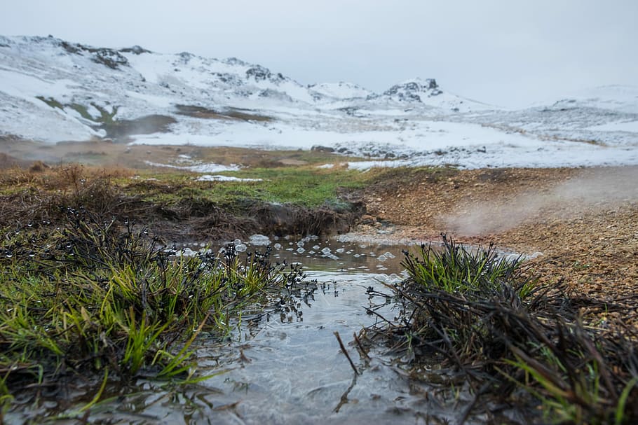 body of water, body of water and green grasses at the foot of snow covered mountain during daytime HD wallpaper