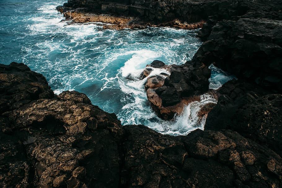 bird's eye body of water and rock formation, ocean waves hitting rocky coastline HD wallpaper