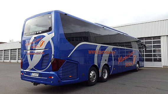 blue and black bus parked near white wooden building at daytime HD wallpaper