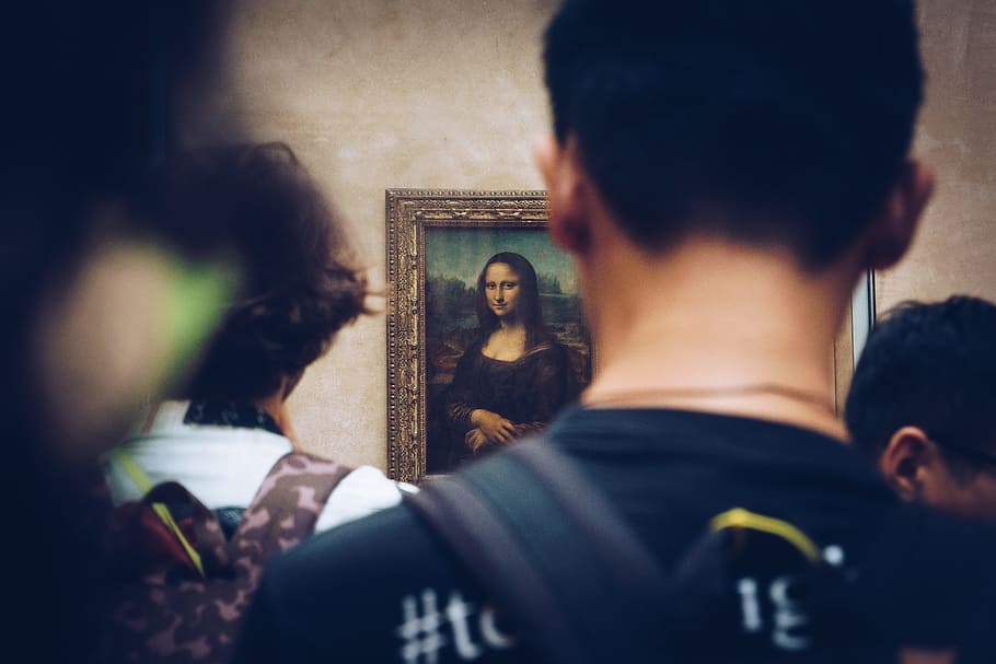 men in front of Mona Lisa painting, people looking Mona Lisa painting hanging on wall