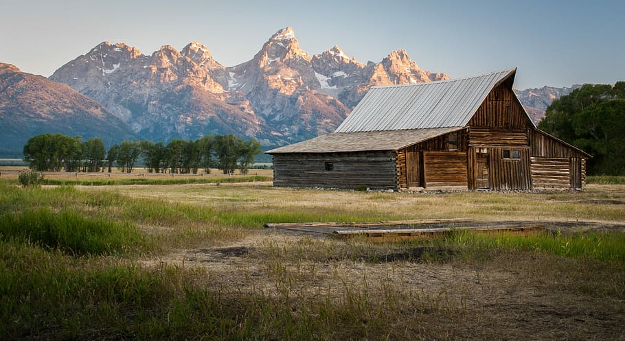 gray wooden barn near the mountain range under the gray skies, brown wooden barn near trees and brown mountains HD wallpaper