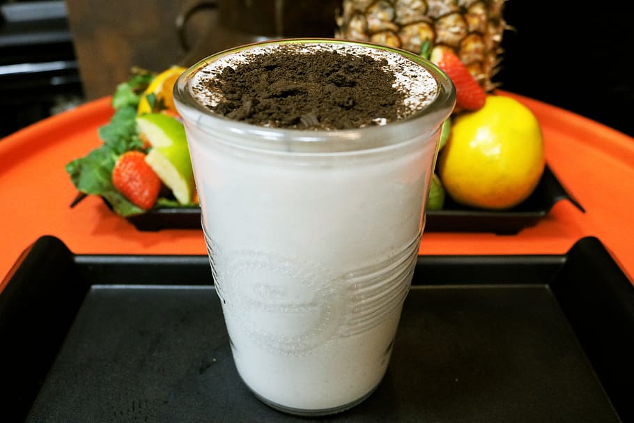 clear drinking glass filled with white liquid with black powder toppings HD wallpaper