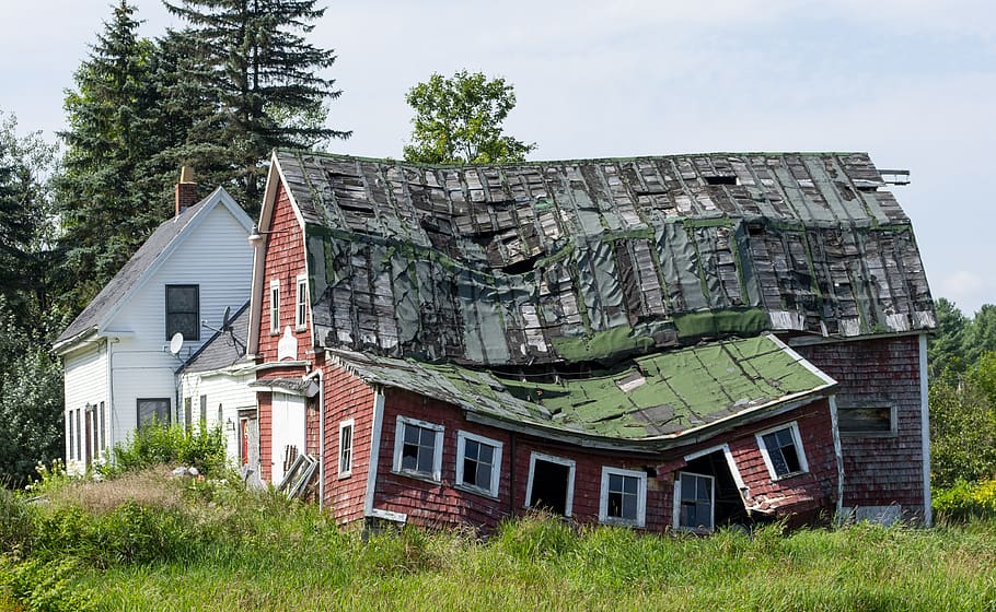 collapsed house, uninhabitable house, crooked roof, roof with holes