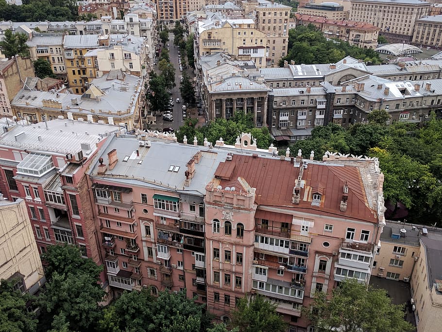 aerial photography of high-rise buildings around city, pink concrete high-rise building near green trees aerial view photo HD wallpaper
